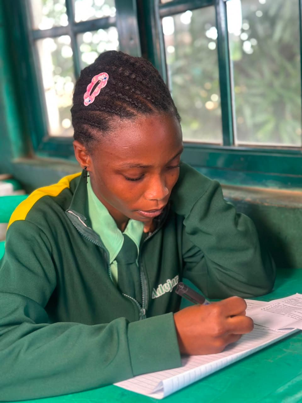 Student in school jacket writing notes